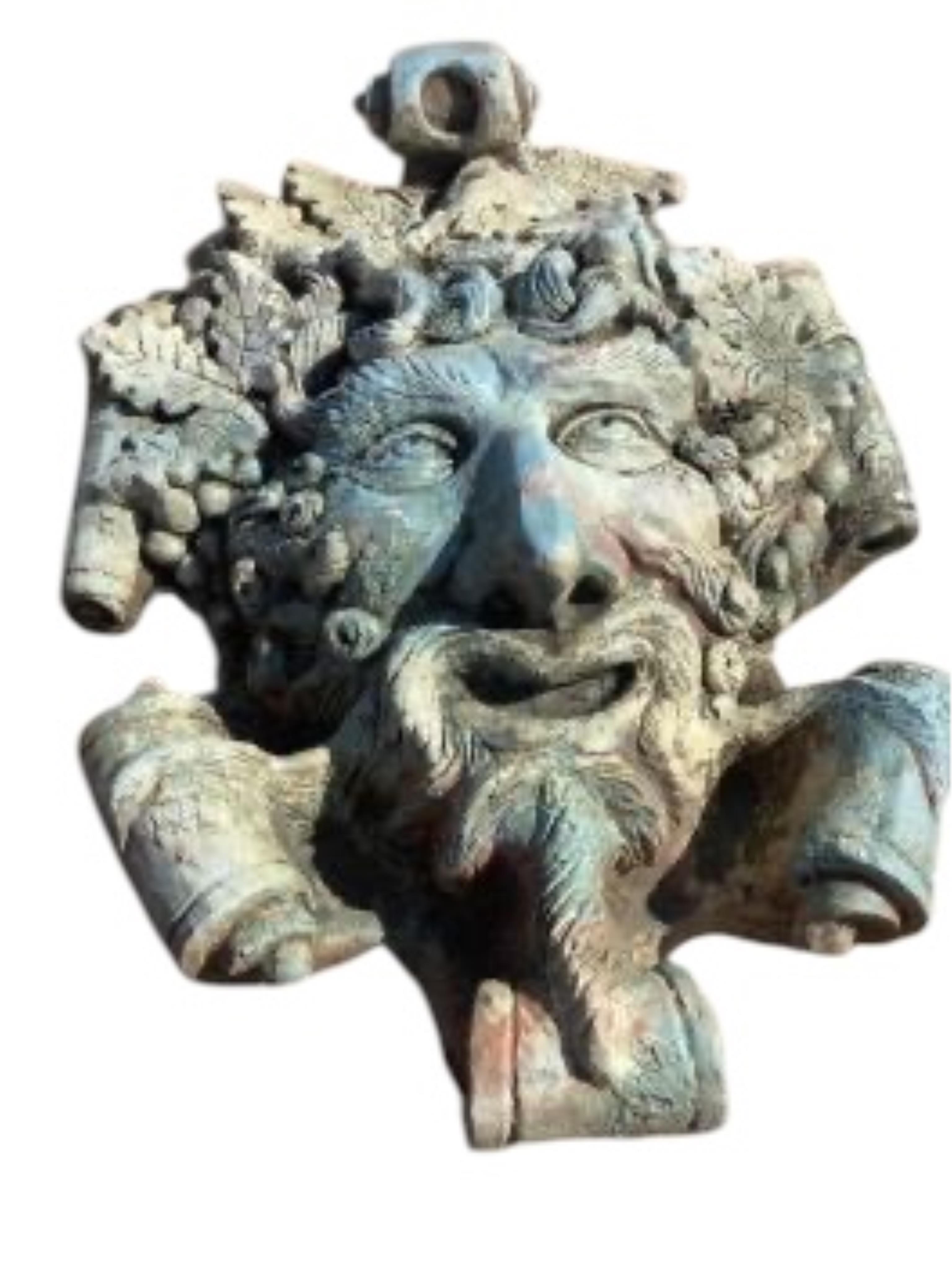 Three cast stone and terracotta garden wall mask appliqués, largest height 42cm